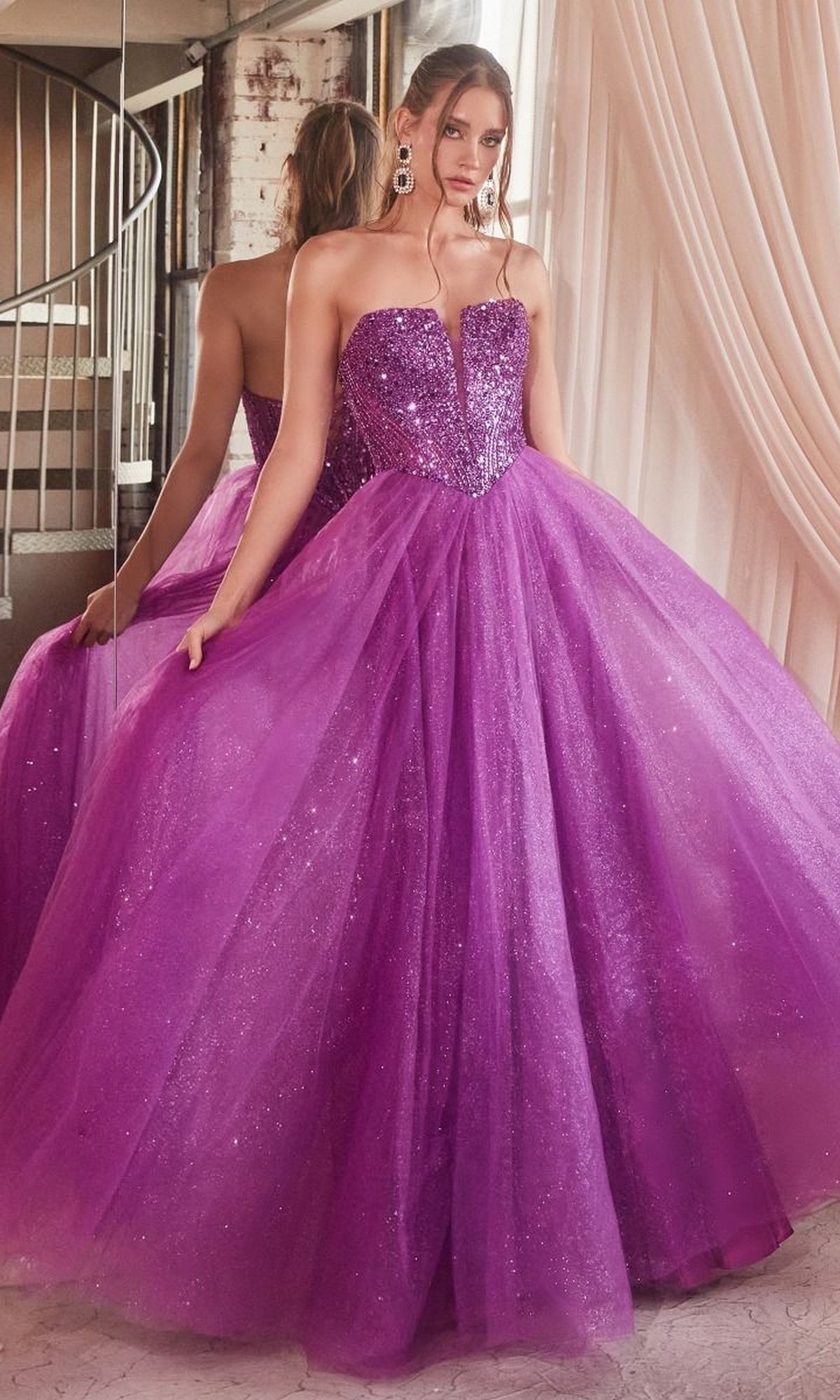 A woman stands in front of a mirror, holding out the sides of her glittery purple tulle skirt while wearing the Lace-Up Strapless Long Glitter Prom Dress CD0217.